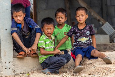 Thakhek, Laos - 20 Nisan 2018: Yerel erkek birlikte Güney Laos uzak bir köyde bir evin önünde oturan Grup
