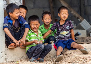 Thakhek, Laos - 20 Nisan 2018: Yerel erkek birlikte Güney Laos uzak bir köyde bir evin önünde oturan Grup