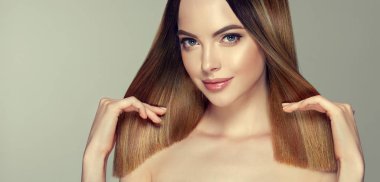 Parlak kahverengi ve düz uzun saçlı güzel model kız. Keratin doğrultma. Tedavi, bakım ve spa prosedürleri. Orta uzunlukta saç modeli. Boyama, ombre, shatush, balage ve vurgulama
