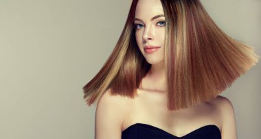 Parlak kahverengi ve düz uzun saçlı güzel model kız. Keratin doğrultma. Tedavi, bakım ve spa prosedürleri. Orta uzunlukta saç modeli. Boyama, ombre, shatush, balage ve vurgulama