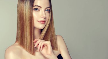 Parlak kahverengi ve düz uzun saçlı güzel model kız. Keratin doğrultma. Tedavi, bakım ve spa prosedürleri. Orta uzunlukta saç modeli. Boyama, ombre, shatush, balage ve vurgulama
