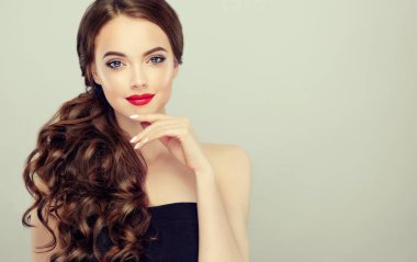 Kıvırcık Kahverengi saçlı güzel model kızı. Dalgalı saç modeli olan esmer kadın. Kırmızı dudaklar, elbise ve manikür çivi. Moda, güzellik ve portre makyaj