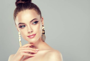 Güzel model kız manikür çivi Tarih ile. Moda makyaj ve kozmetik. Büyük altın Parlatıcı küpe takı .