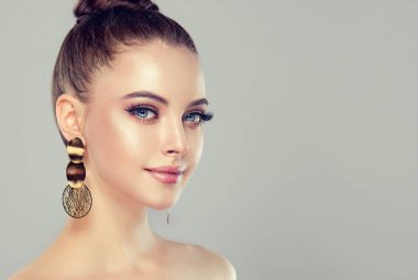Güzel model kız moda makyaj ve kozmetik. Büyük altın Parlatıcı küpe takı .