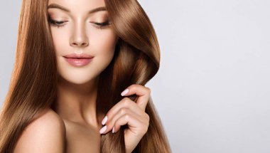 Parlak kahverengi ve düz uzun saçlı güzel model kız. Keratin doğrultma. Tedavi, bakım ve spa prosedürleri. Orta uzunlukta saç modeli. Boyama, ombre, shatush, balage ve vurgulama