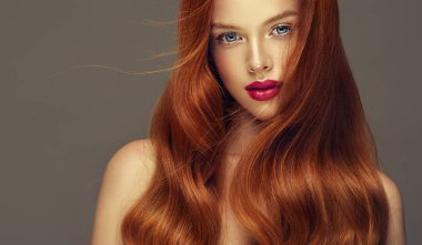 Dalgalı saçlı uzun ve parlak kırmızı baş kız. Güzel model kadın kıvırcık saç modeli ile .