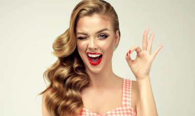 Pin-up retro girl with curly hair  winking, smiling and showing OK sign . Presenting your product. Expressive facial expressions clipart