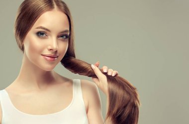 Parlak kahverengi ve düz uzun saçlı güzel model kız. Keratin doğrultma. Tedavi, bakım ve spa prosedürleri. Düz saç modeli
