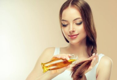 Parlak kahverengi ve düz uzun saçlı güzel model kız. Yağı özü, bakım ve spa prosedürler ile tedavi. Düz saç modeli 