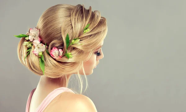 髪型と花を持つ若い ブロンドの髪の女性 — ストック写真