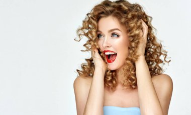 Kırmızı dudakları ve tırnakları olan kadın şaşkınlık ve sevinç çığlıkları atıyor. Kıvırcık saçlı güzel kız şaşırttı ve sevinççığlık şok . Ürününüzü sunmak. Etkileyici yüz ifadeleri