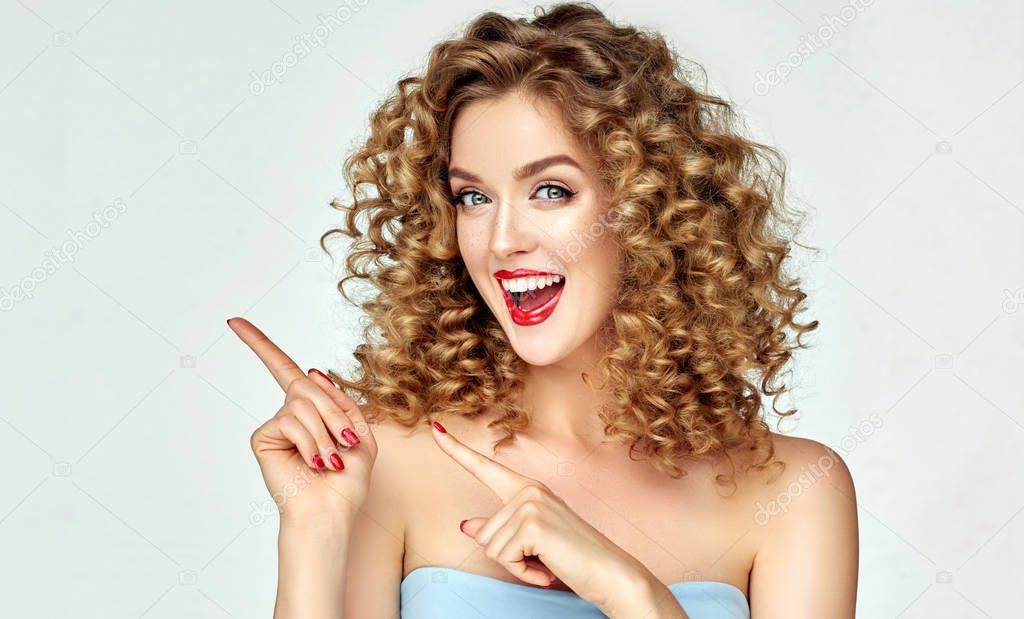 Young woman shows and advertises some product .Beautiful girl pointing to the side . Presenting your services. Expressive facial expressions emotions