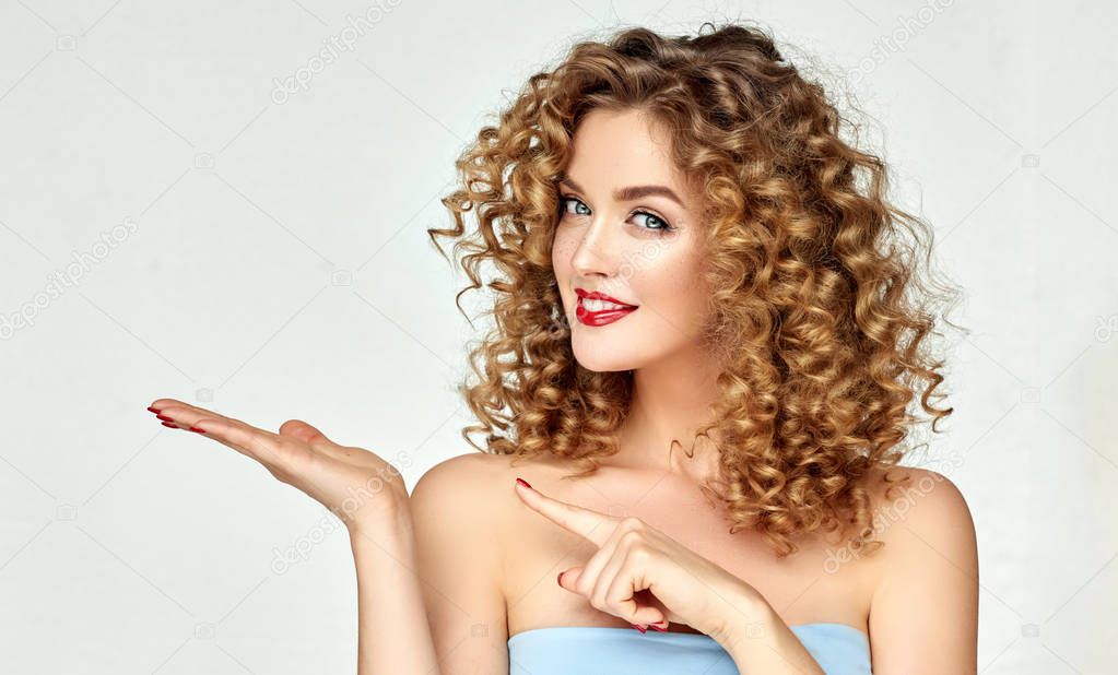 Young woman shows and advertises some product .Beautiful girl pointing to the side . Presenting your services. Expressive facial expressions emotions