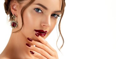 Beautiful model girl with burgundy or wine color manicure on nails . Fashion makeup and cosmetics . Jewelry, earrings and accessories. Beauty woman with braid hairstyle around her head. clipart