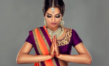 Güzel Hintli bir kızın portresi. Tatoo mehndi ve kundan mücevherli genç Hindu kadın model. Geleneksel Hint kostümü lehenga choli .