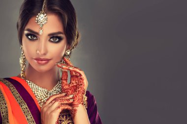 Güzel Hintli bir kızın portresi. Tatoo mehndi ve kundan mücevherli genç Hindu kadın model. Geleneksel Hint kostümü lehenga choli .
