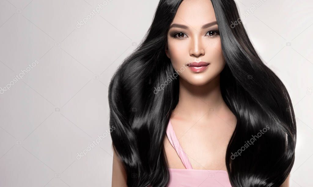 Beautiful asian model girl with shiny black and straight long hair . Keratin straightening . Treatment, care and spa procedures for hair . Chinese girl with smooth hairstyle