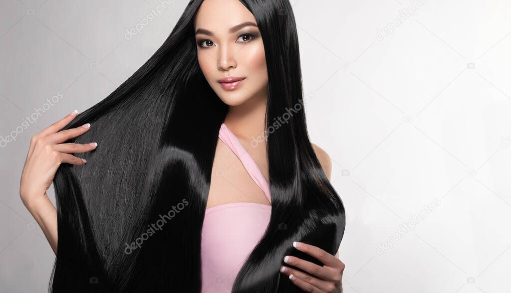 Beautiful asian model girl with shiny black and straight long hair . Keratin straightening . Treatment, care and spa procedures for hair . Chinese girl with smooth hairstyle