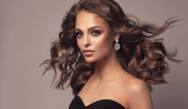 Dalgalı ve parlak saçlı güzel bir manken kız. Kıvırcık saçlı, gülümseyen esmer kadın.