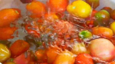 Tomatoesclose yıkama eller. Sebze ve temiz su.