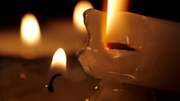 Горящая свеча на черном фоне. Символ религии — стоковое видео