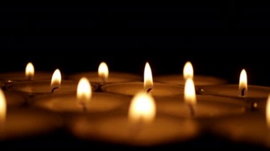 Siyah bir arka plan üzerinde mum yakmak. Din sembolü