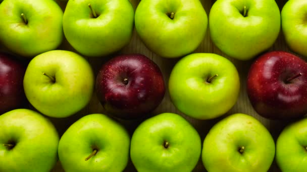 Červené jablko v zelených jablkách. Mnoho jablek u stolu. Zdravá strava — Stock video