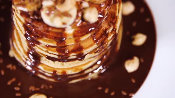 Pannenkoeken met chocoladesiroop, noten en bananen. Stapel hele flapjack. Lekker ontbijt en gezonde voeding — Stockvideo