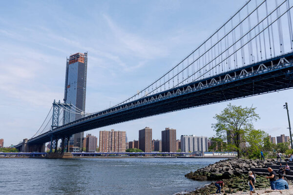 Manhattan, New York City - May 10, 2018 : Side view of Manhattan Bridge structure and New York buildings