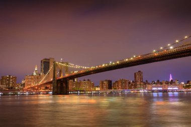 Gün batımında New York'ta hudson Nehri üzerinde Brooklyn Köprüsü.