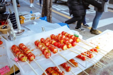 Seoul, Güney Kore - 2 Mart 2018: Erimiş şeker, insansız veya katılımsız kiosk alışveriş caddesi Hongdae (Hongik Üniversitesi), küçük römork üzerinde çilek sopa kaplı.