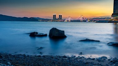 Busan, Güney Kore - 8 Ağustos 2018: Gwangan köprü ışık ve güzel alacakaranlık gökyüzü, Haeundae Busan City, gün batımı