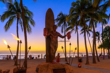 Honolulu, Hawaii - 23 Aralık 2018: Duke Kahanamoku ikonik heykeli gün batımında Waikiki Beach