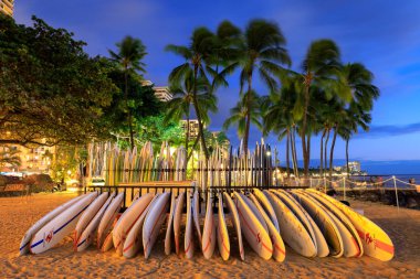 Honolulu, Hawaii - 23 Aralık 2018: Landmark Waikiki Beach günbatımında sörf tahtaları yığında