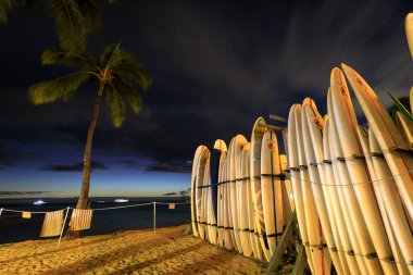 Honolulu, Hawaii - 23 Aralık 2018: Landmark Waikiki Beach günbatımında sörf tahtaları yığında