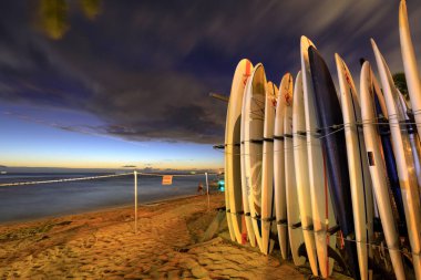 Honolulu, Hawaii - 23 Aralık 2018: Landmark Waikiki Beach günbatımında sörf tahtaları yığında