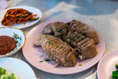 bossam, tuzlu sos ile yenilen ve yeşillik sarılmış haşlanmış domuz, bossam kimchi