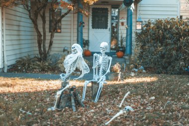 Cadılar Bayramı açık hava süslemeleri. Özel evin ön bahçesi sahte kafatası, kemik eller, mezar taşları ve ızgaralarla dekore edilmiş..