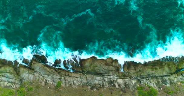 Aérea: Las olas del océano están lavando grandes rocas en la costa rocosa del mar . — Vídeos de Stock