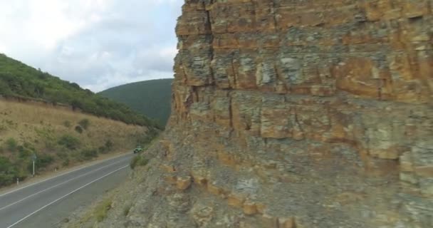 Повітряні: Дівчина стоїть на автомобілі, їзда на дорозі між горами. — стокове відео