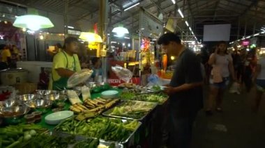 Phuket, Tayland 9 Eylül 2018: Bir Asya gece pazarı. Alıcı sebze satıcıdan satın..