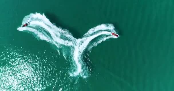 Aerial: Two water bikes jet ski are draw a heart shape on the water on the sea. — Stock Video