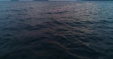Gün batımında su yüzeyinde güneşe doğru uçmak.