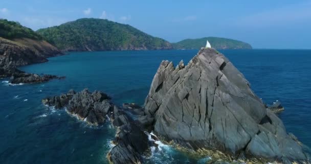 Yacht, katamarán fehér vitorlákkal lebeg ki egy sziklás szikla mögül. — Stock videók