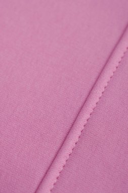 Düzgün dikişli pembe kumaş. Pamuk.