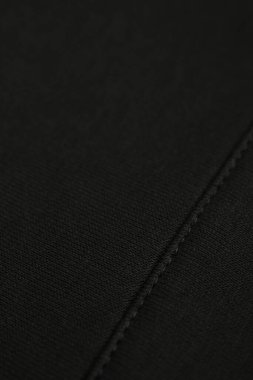 Düzgün dikişli haki kumaş. Siyah pamuk.