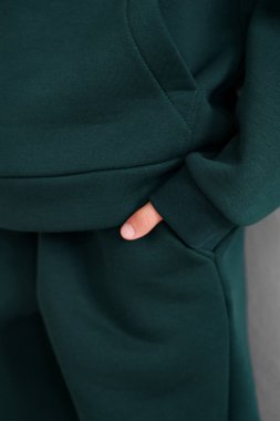 Cebinde kelepçe olan yeşil kapüşonlu. Sıcak eşofman kolunun yakın çekimi. Pamuk.