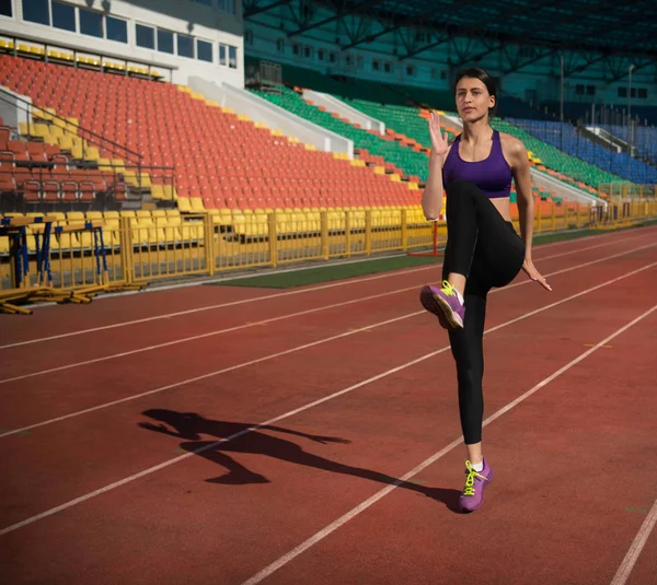 track and field woman doing exercise at the stadium