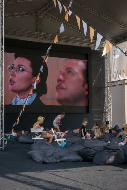 Moskova - 4 Ağustos 2018: İnsanlar çocuklarla çuval oturan ve Moskova Sineması projesi kapsamında farklı alanlarda Moskova'da kurmak yaz açık hava sinema filmi izlerken rahatlatıcı