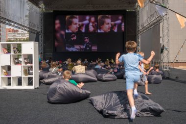 Moskova - 4 Ağustos 2018: insanları çuval ve having fun yaz açık hava sinema Moskova Sineması projesi kapsamında farklı alanlarda Moskova'da kurmak çocuk oturan film izlemek